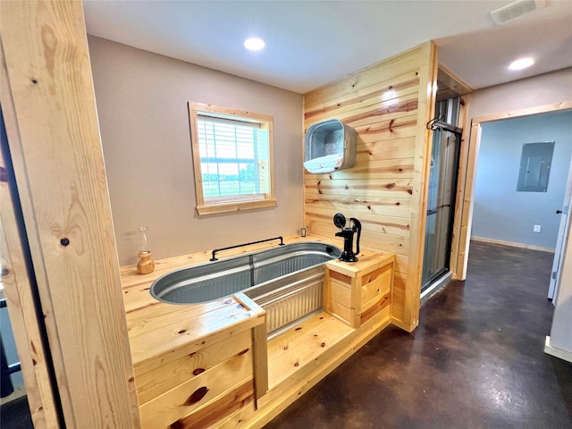 bathroom with wood walls, concrete floors, and electric panel