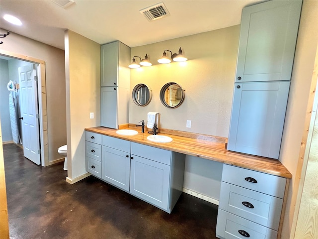 bathroom with concrete floors, toilet, and vanity