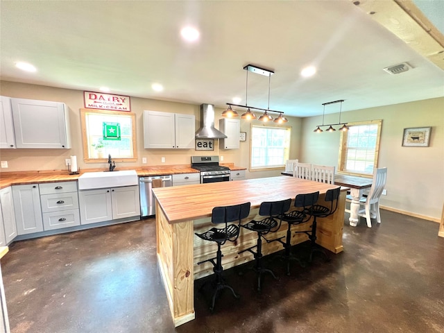 kitchen featuring appliances with stainless steel finishes, wood counters, white cabinets, and sink