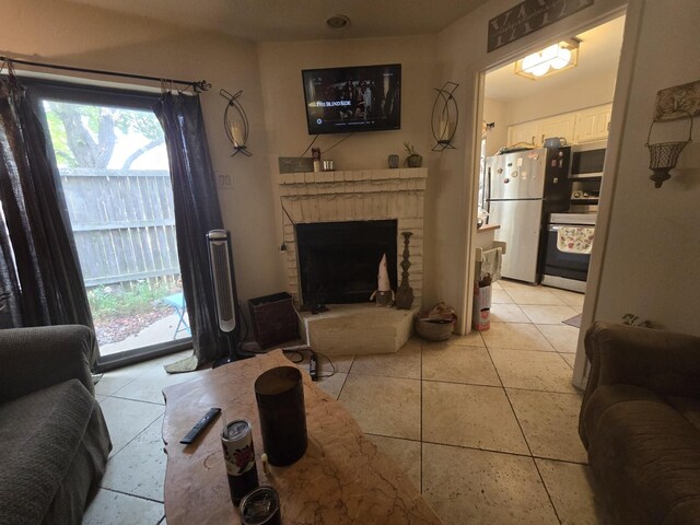 living area with a brick fireplace and light tile patterned floors