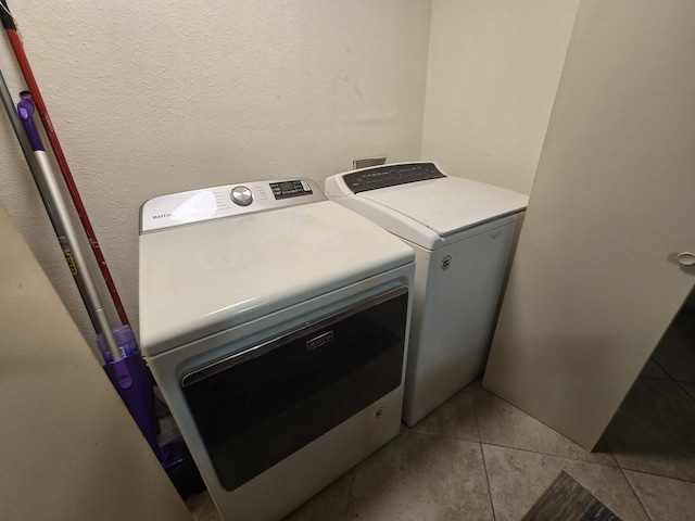 washroom featuring laundry area, tile patterned flooring, and washing machine and clothes dryer