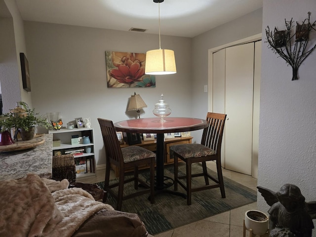 tiled dining space featuring visible vents