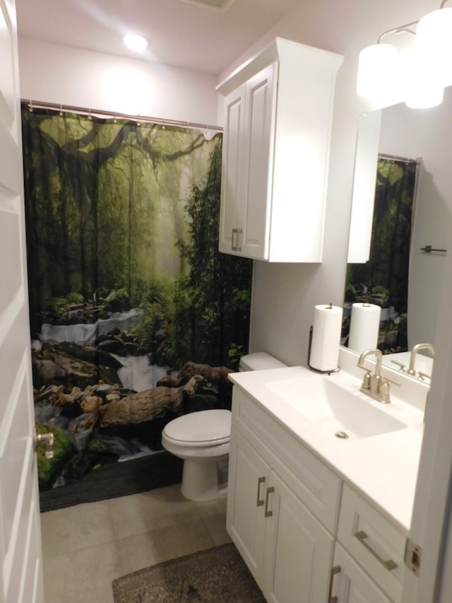 bathroom featuring tile patterned floors, vanity, and toilet