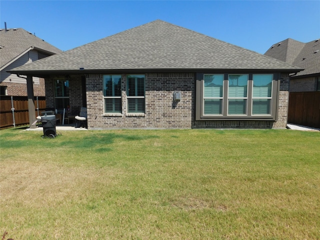 rear view of property featuring a patio and a yard