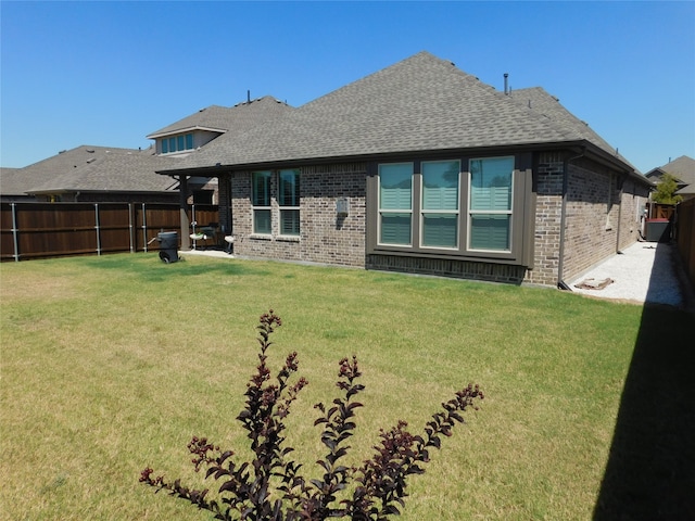 rear view of property featuring a lawn