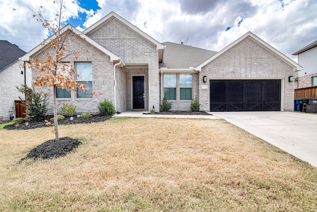 view of front of property with a front yard and a garage