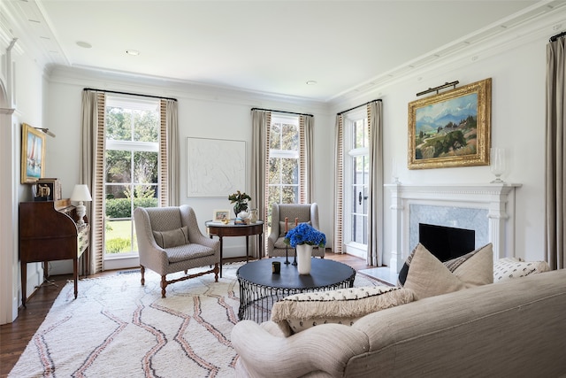 living room featuring a high end fireplace, hardwood / wood-style floors, and ornamental molding