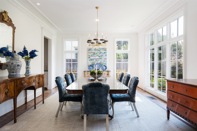 dining room featuring a notable chandelier, light hardwood / wood-style flooring, and ornamental molding