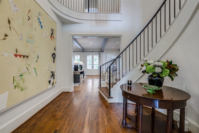 entrance foyer featuring a towering ceiling and hardwood / wood-style floors