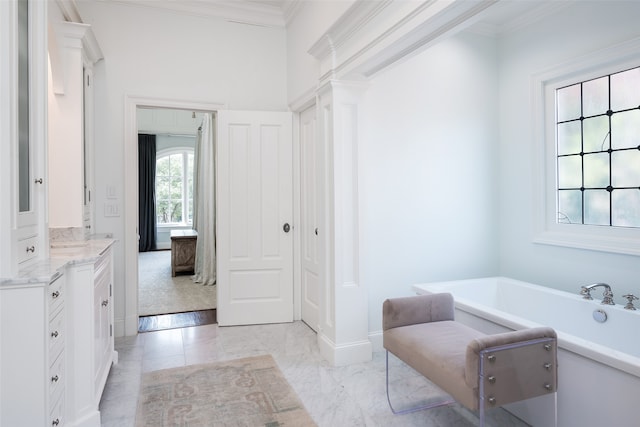 bathroom featuring tile patterned flooring, crown molding, a tub to relax in, and vanity