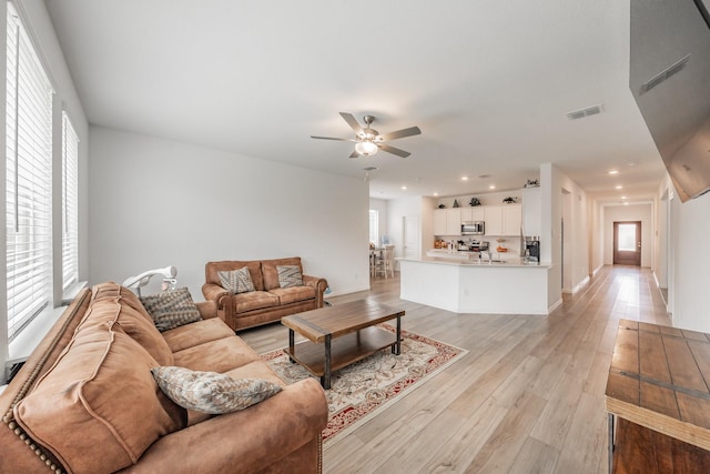 living area featuring light wood-style flooring, visible vents, ceiling fan, baseboards, and recessed lighting