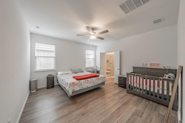 bedroom featuring baseboards, visible vents, and wood finished floors