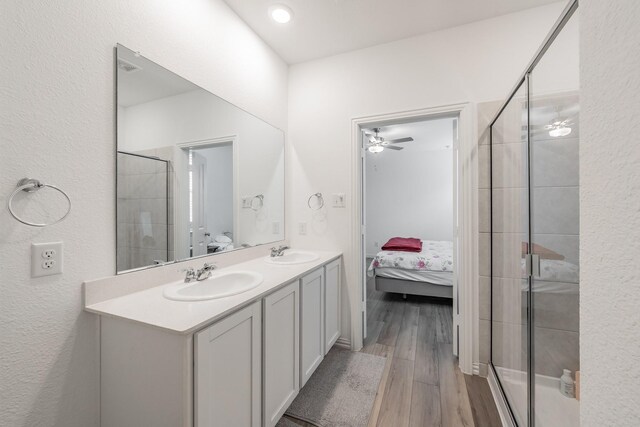 full bath featuring double vanity, ensuite bathroom, a stall shower, and a sink