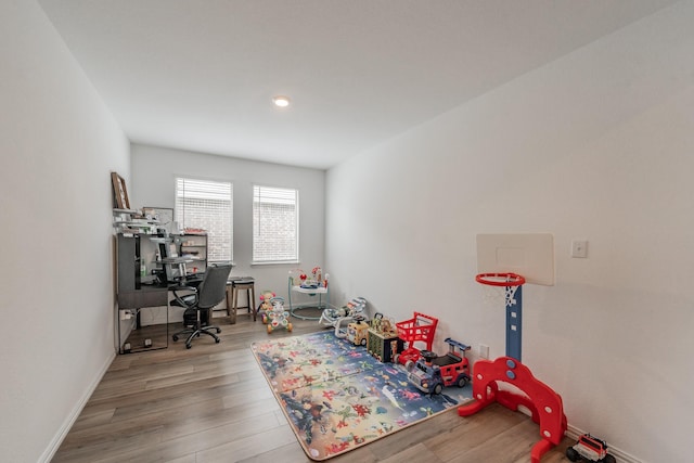 recreation room with wood finished floors and baseboards