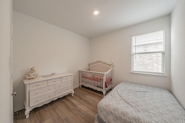 bedroom with baseboards and wood finished floors