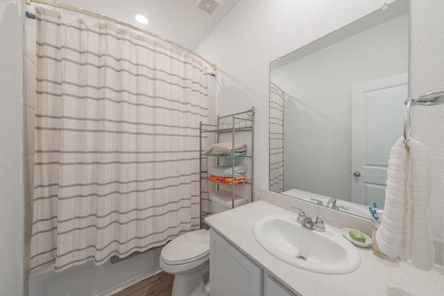 full bathroom with shower / bath combination with curtain, vanity, hardwood / wood-style floors, and toilet