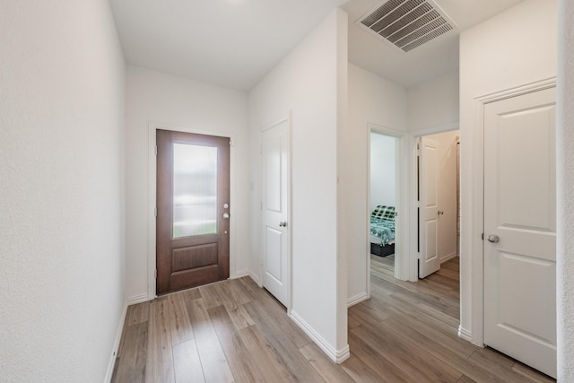 foyer featuring visible vents, light wood-style flooring, and baseboards