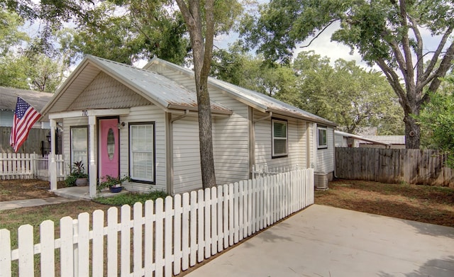 bungalow featuring a fenced front yard and metal roof