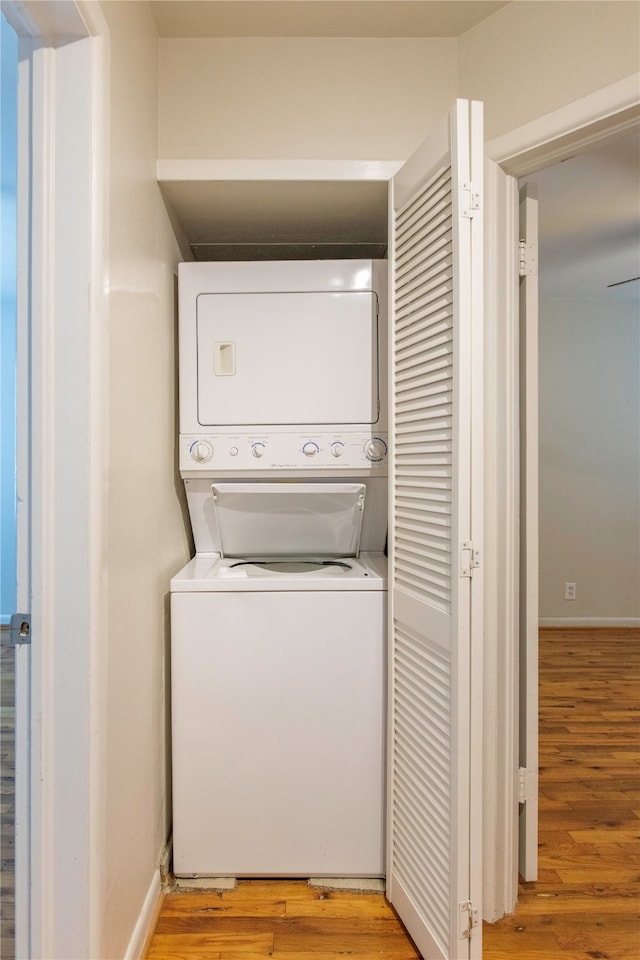 laundry area with light wood-type flooring and stacked washer and dryer