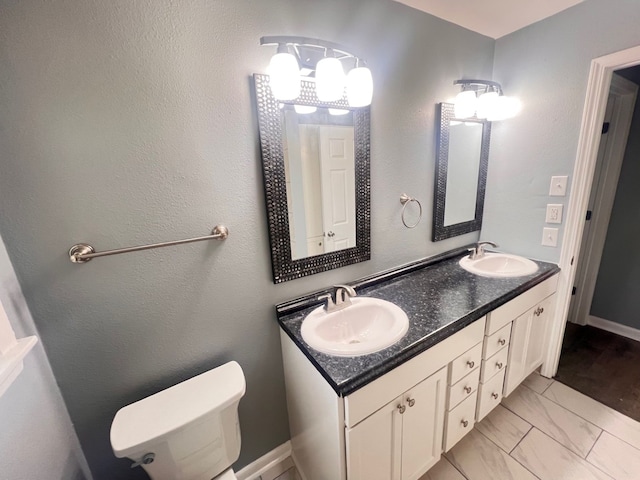 bathroom with toilet, double sink vanity, and tile patterned floors