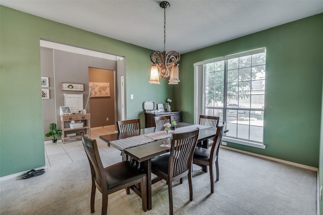 carpeted dining area featuring a chandelier