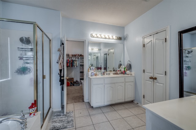 bathroom with tile patterned floors, vanity, and walk in shower