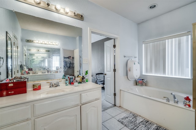 bathroom with tile patterned flooring, a bathtub, and vanity