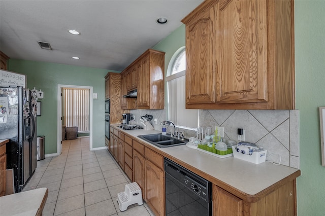 kitchen featuring sink, light tile patterned flooring, black appliances, and backsplash