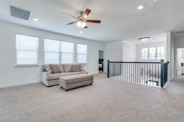 carpeted living room featuring ceiling fan