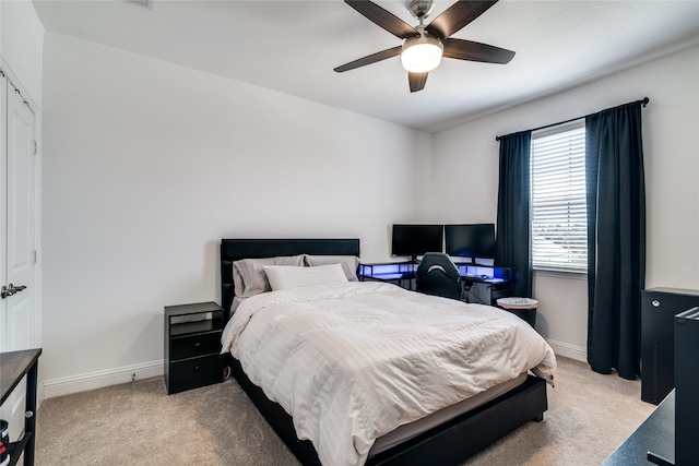 bedroom with ceiling fan, light carpet, and a closet