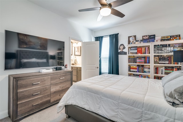 bedroom with light colored carpet, ceiling fan, and ensuite bathroom