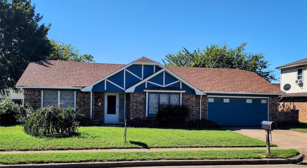 view of front of property featuring a garage and a front lawn