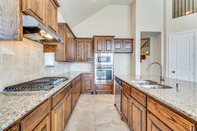 kitchen featuring sink, high vaulted ceiling, appliances with stainless steel finishes, light stone counters, and light tile patterned floors