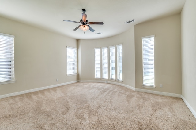 carpeted spare room with ceiling fan