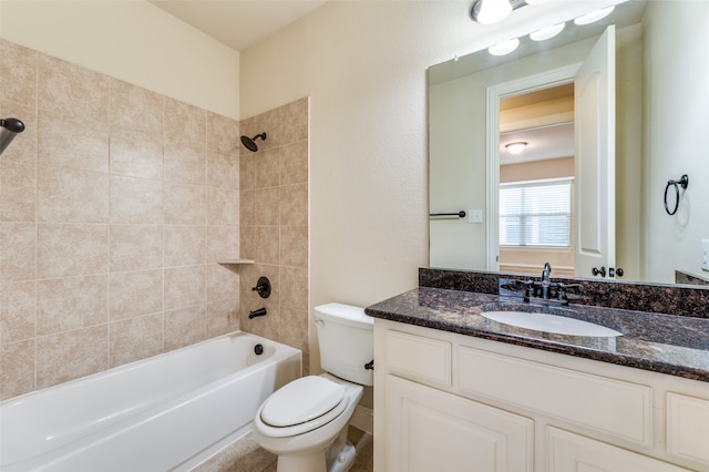 full bathroom featuring tiled shower / bath, toilet, and vanity