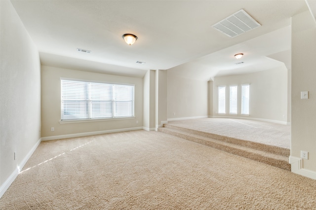 carpeted empty room featuring a wealth of natural light