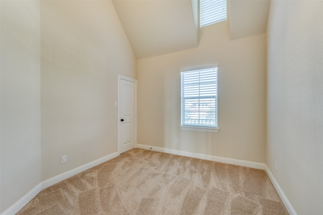 unfurnished room featuring lofted ceiling and light carpet