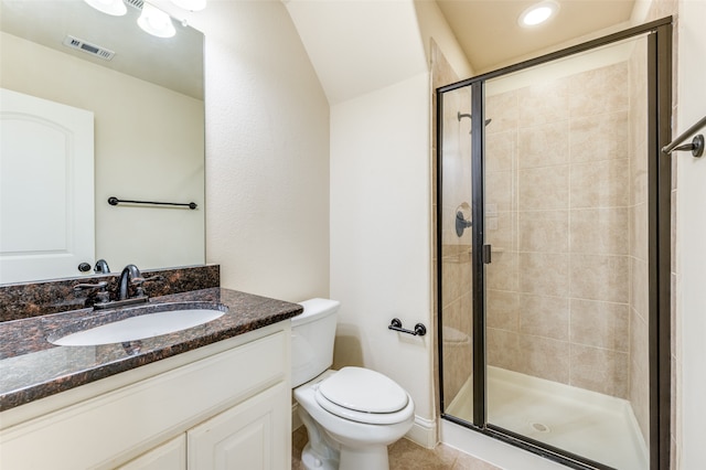 bathroom with a shower with door, toilet, vanity, and tile patterned floors