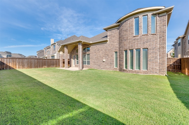 rear view of house with a patio area and a lawn