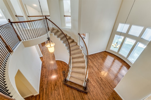 stairs with a towering ceiling and hardwood / wood-style floors