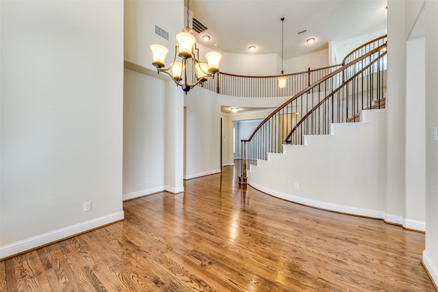 entryway featuring a high ceiling, a notable chandelier, and hardwood / wood-style flooring