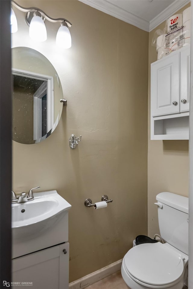 bathroom featuring toilet, vanity, and ornamental molding