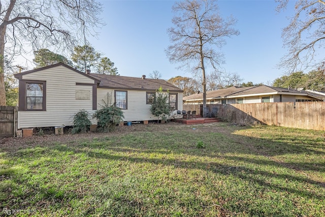 rear view of house featuring a yard and a deck