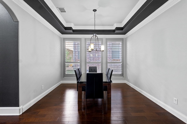 dining area featuring a raised ceiling, hardwood / wood-style flooring, crown molding, and a notable chandelier