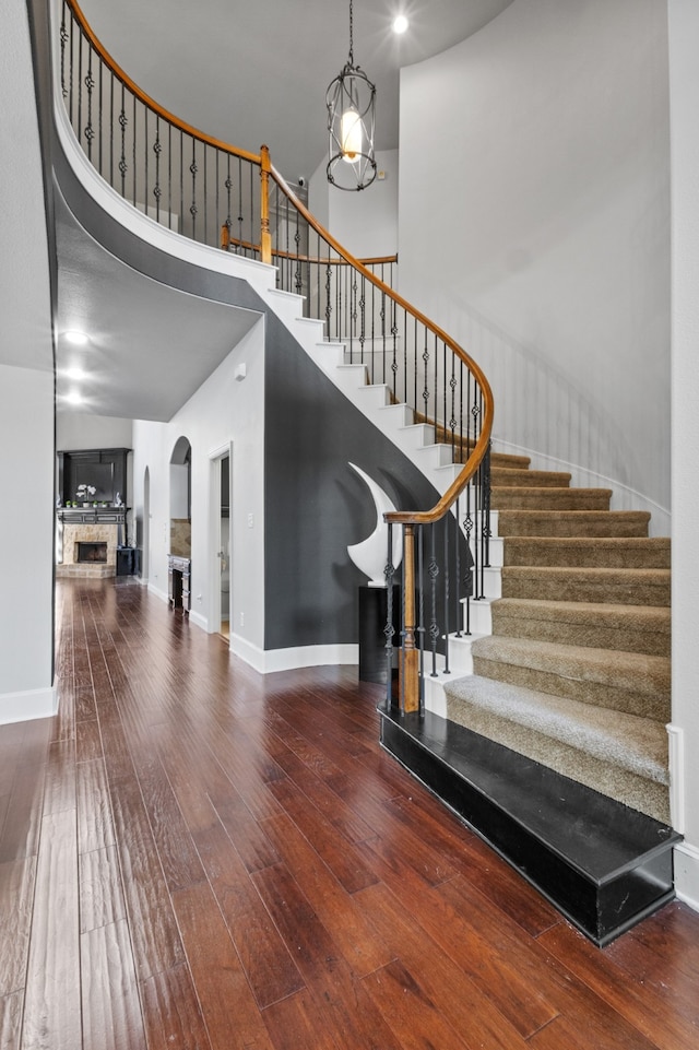 stairs with wood-type flooring and a chandelier