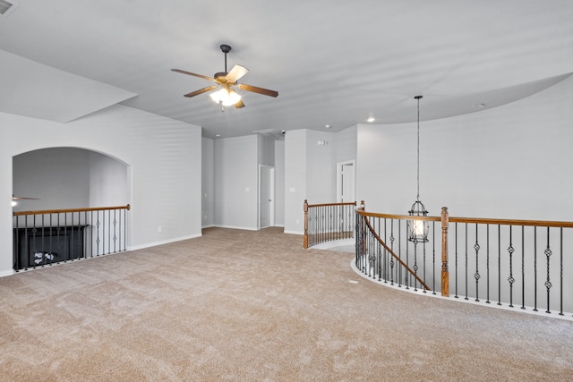 carpeted spare room with ceiling fan with notable chandelier and vaulted ceiling