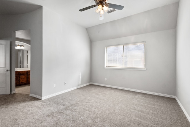 empty room with ceiling fan, lofted ceiling, and light carpet