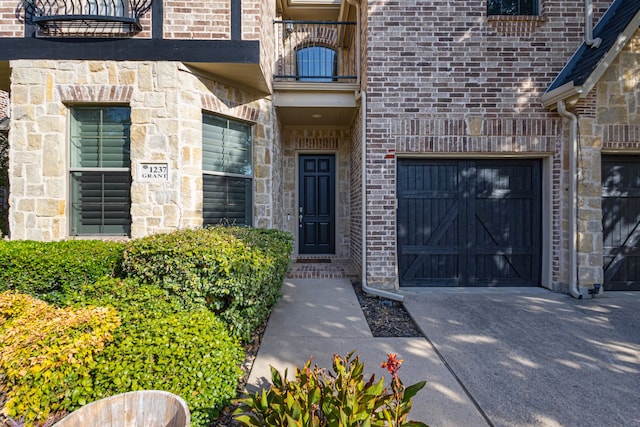 entrance to property featuring a garage and a balcony