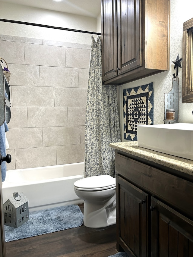 full bathroom with toilet, hardwood / wood-style flooring, shower / bath combo with shower curtain, and vanity