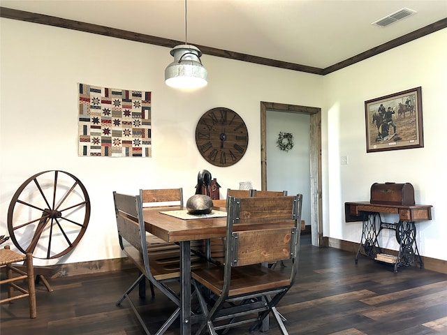 dining space featuring dark wood-type flooring and ornamental molding